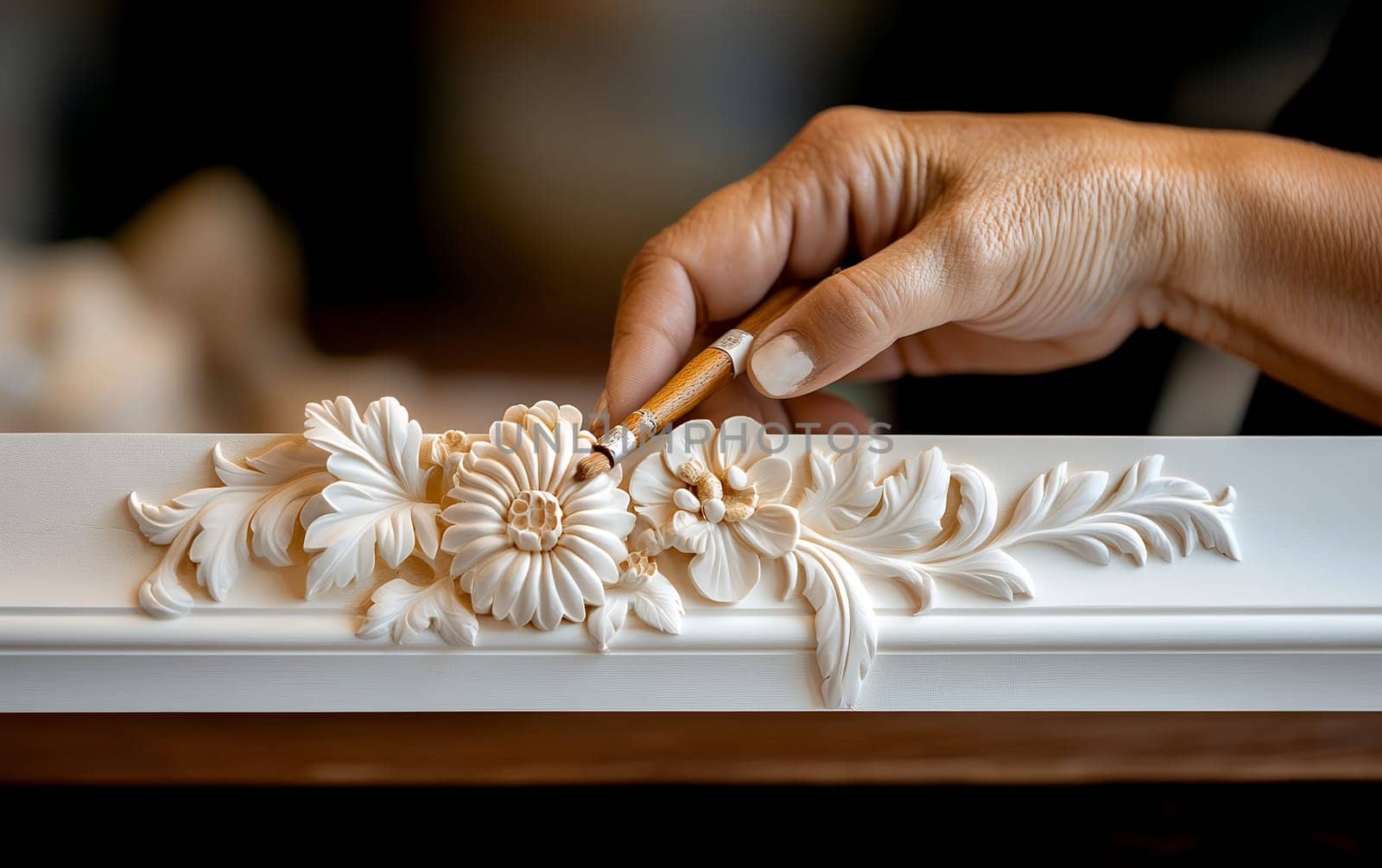 Intricate hand-carved floral design on wooden frame by craftsperson.