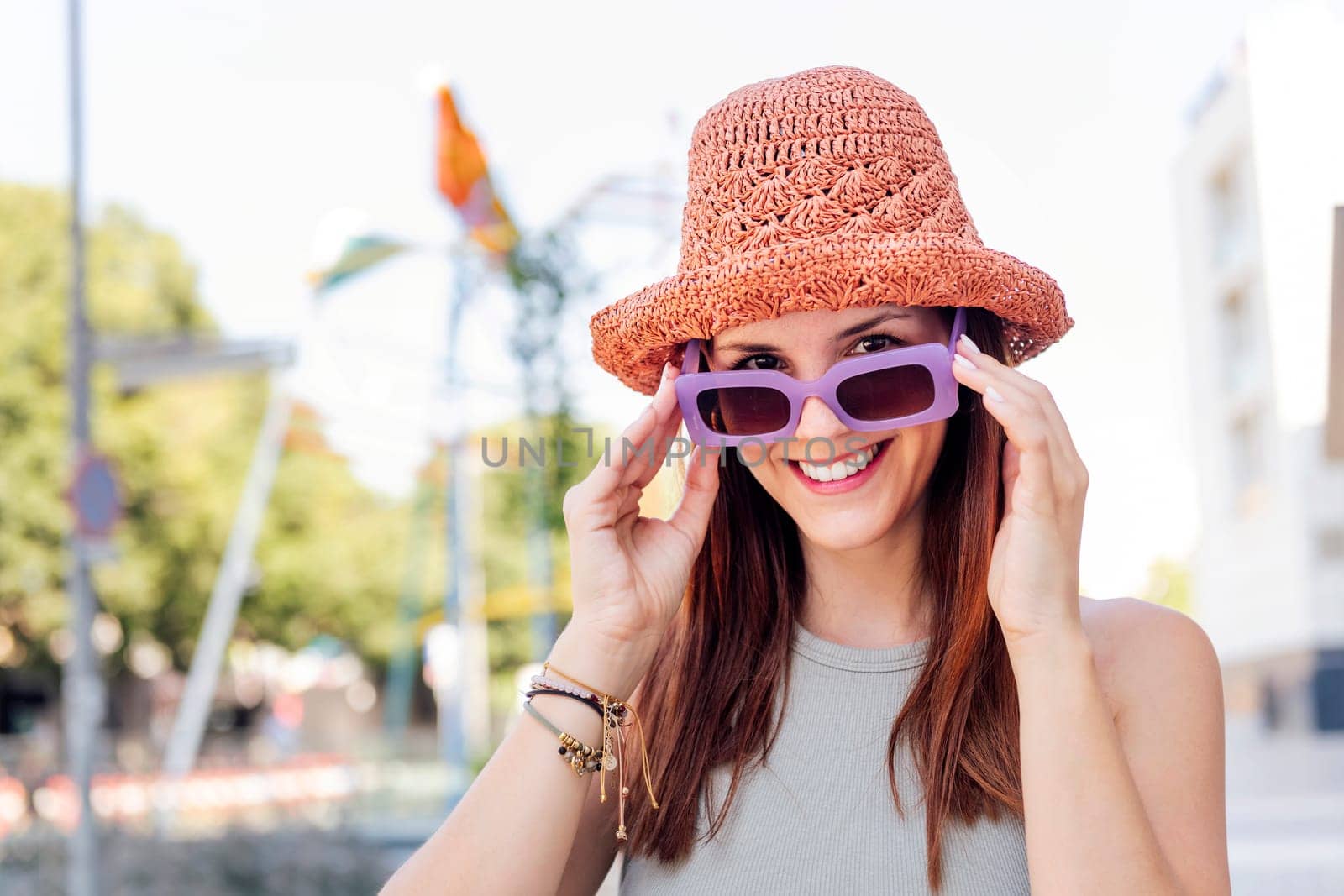 portrait of a happy young woman with hat smiling looking at camera over sunglasses, concept of youth, copy space for text