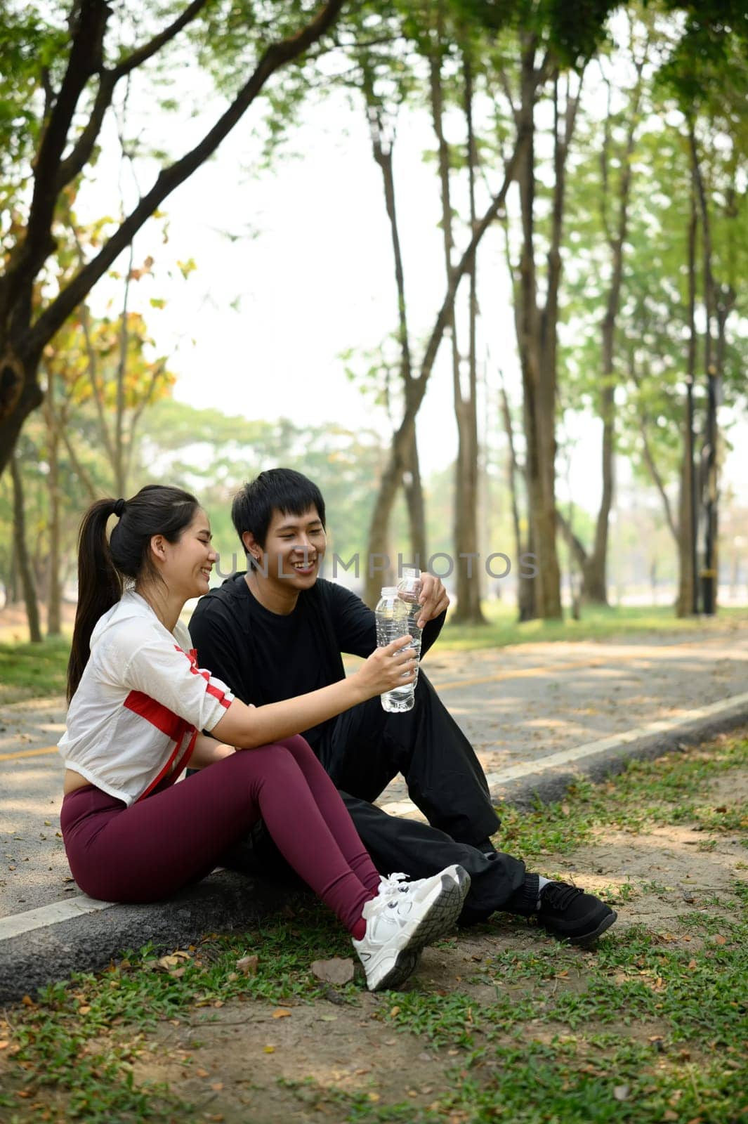Young couple taking a break after outdoor exercise. Wellness and healthy lifestyle concept.