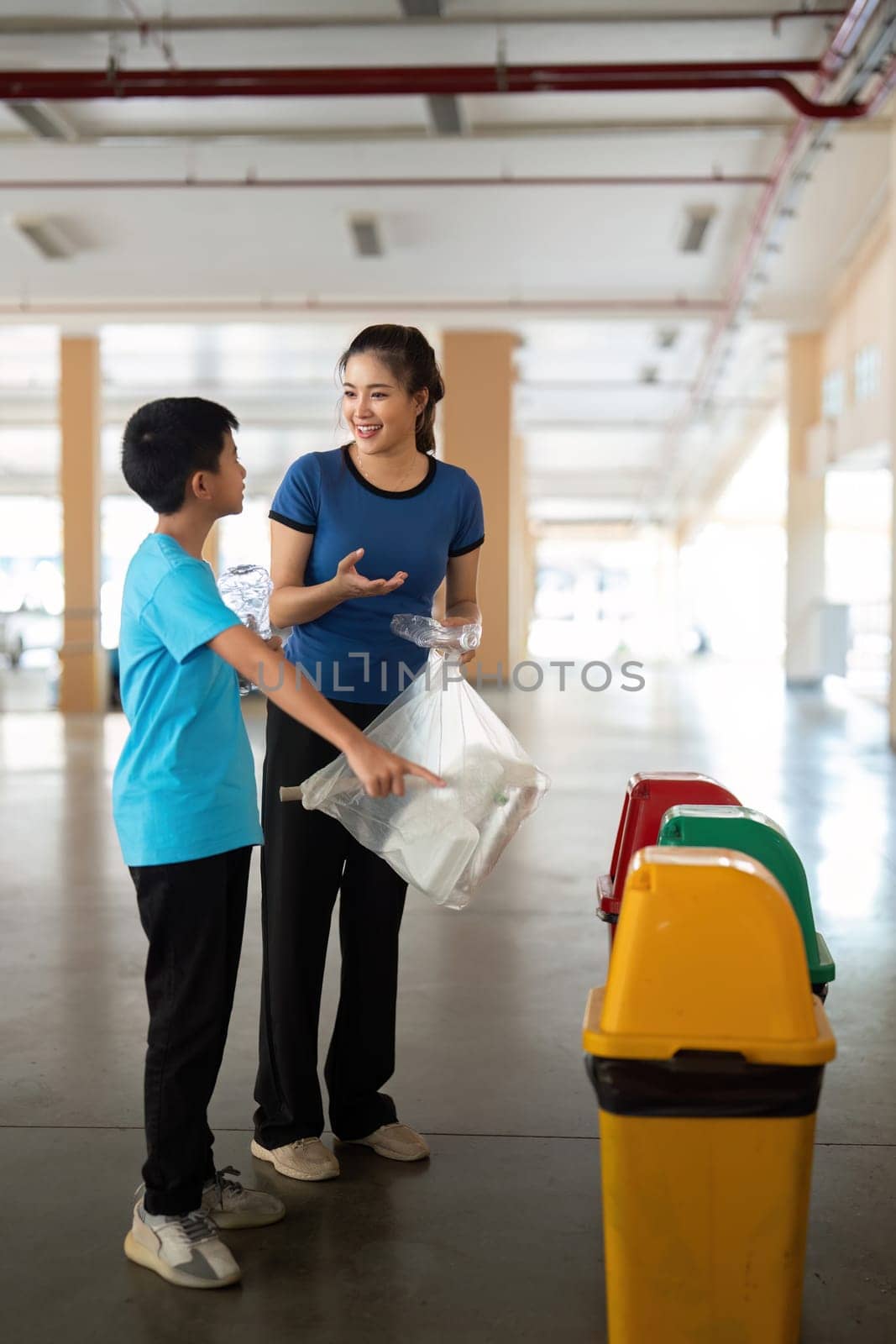 A caregiver engages a child in a fun activity focused on recycling, discussing the importance of sorting waste for a cleaner planet.