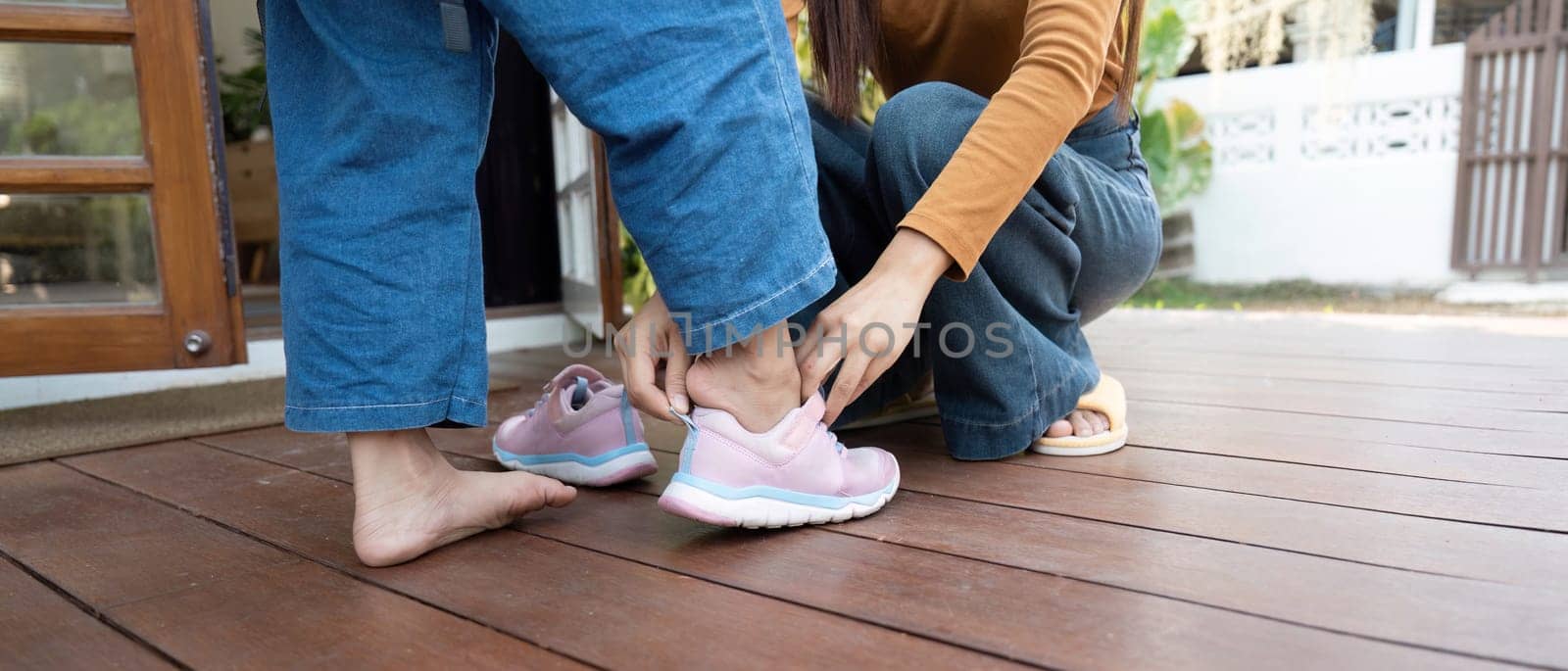 A caring mom assists her daughter with her shoes, emphasizing the nurturing moments before school. Their bond is highlighted in this everyday activity.