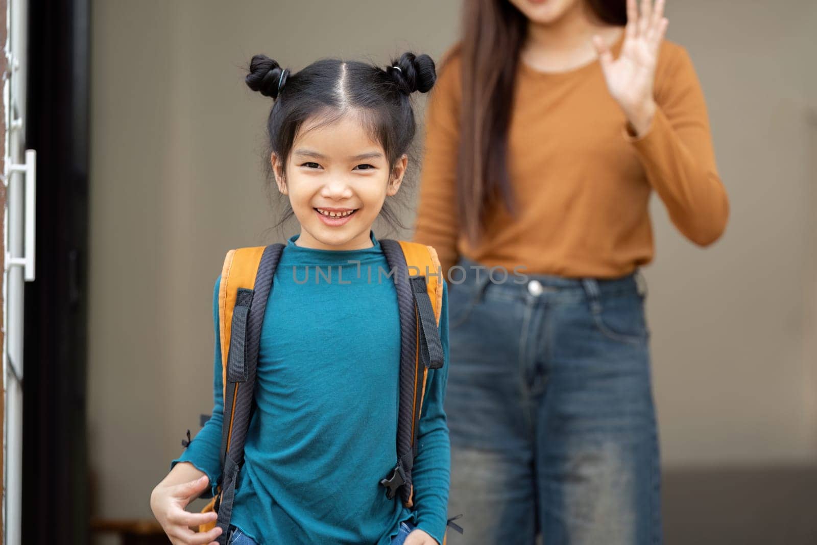 The girl grins at the camera as she prepares to step outside, showcasing a moment filled with excitement and a sense of belonging.