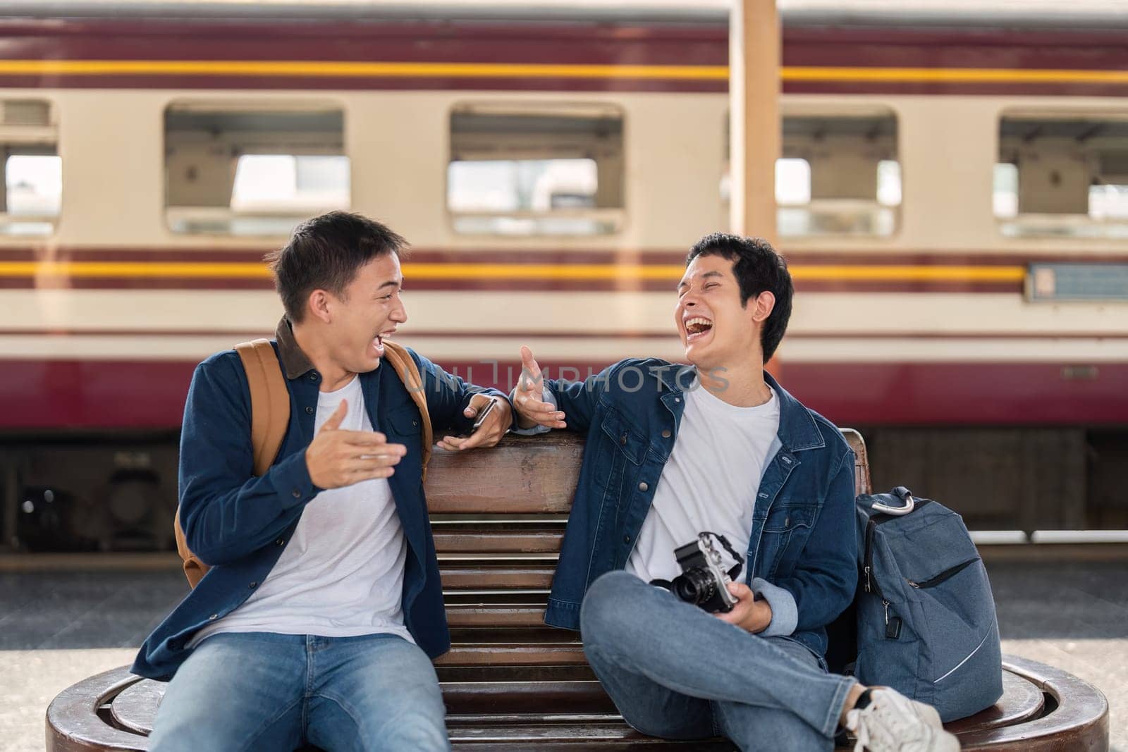 Two friends catch up on their journey at the train station, sharing stories and laughter. Their genuine connection reflects the joy of travels together.