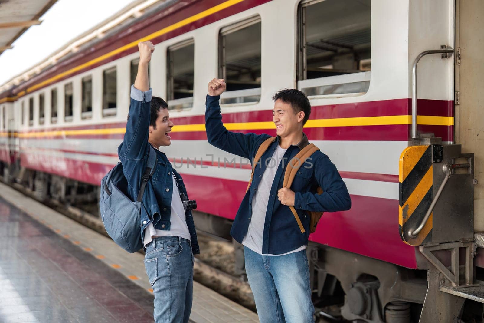Eager travelers express their joy at the train station, ready for a new adventure together. Their enthusiasm reflects the spirit of travel and camaraderie.