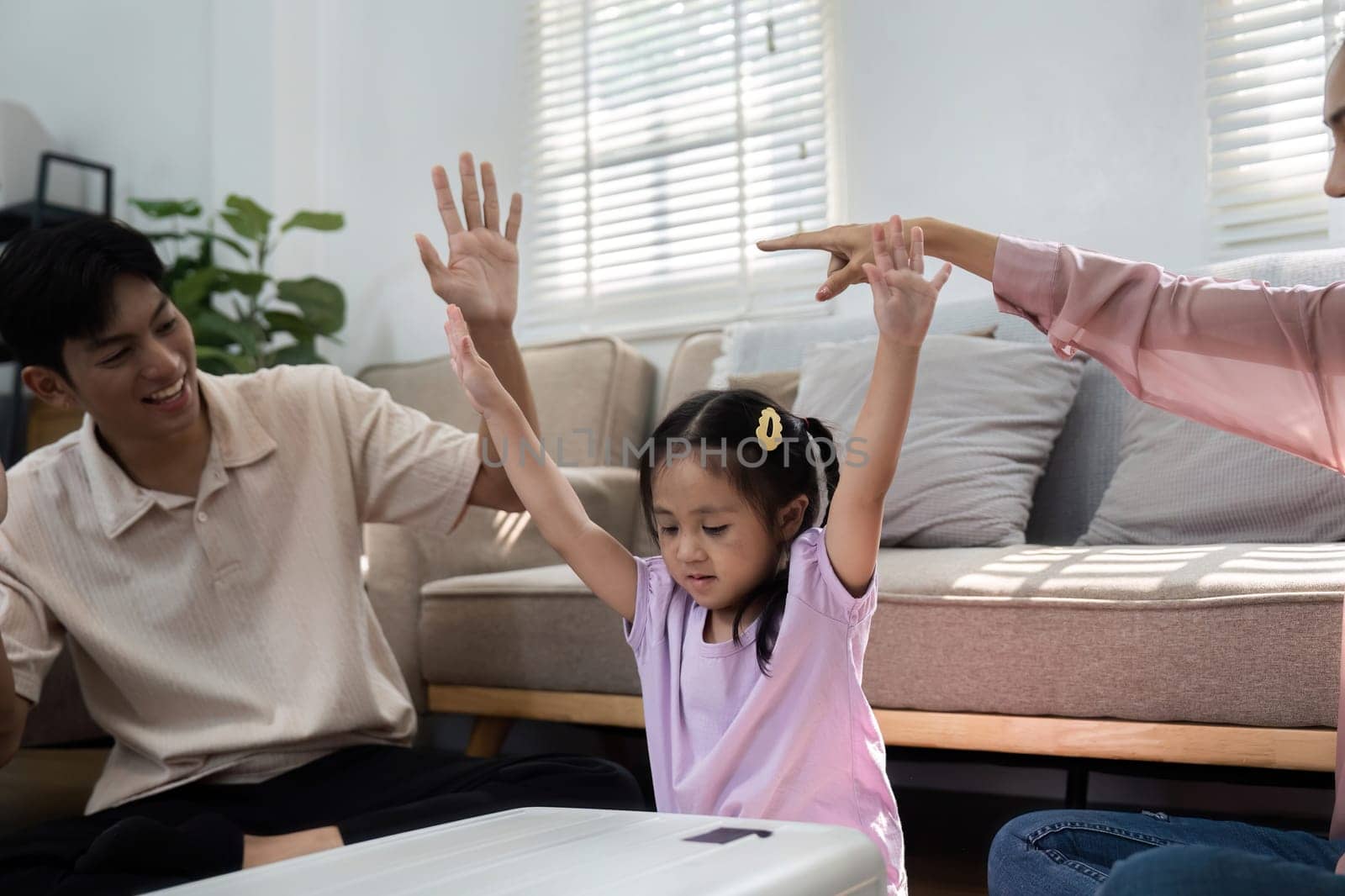 The daughter celebrates with her hands raised as her parents cheer, highlighting the joyous anticipation of family travels and shared moments of connection.