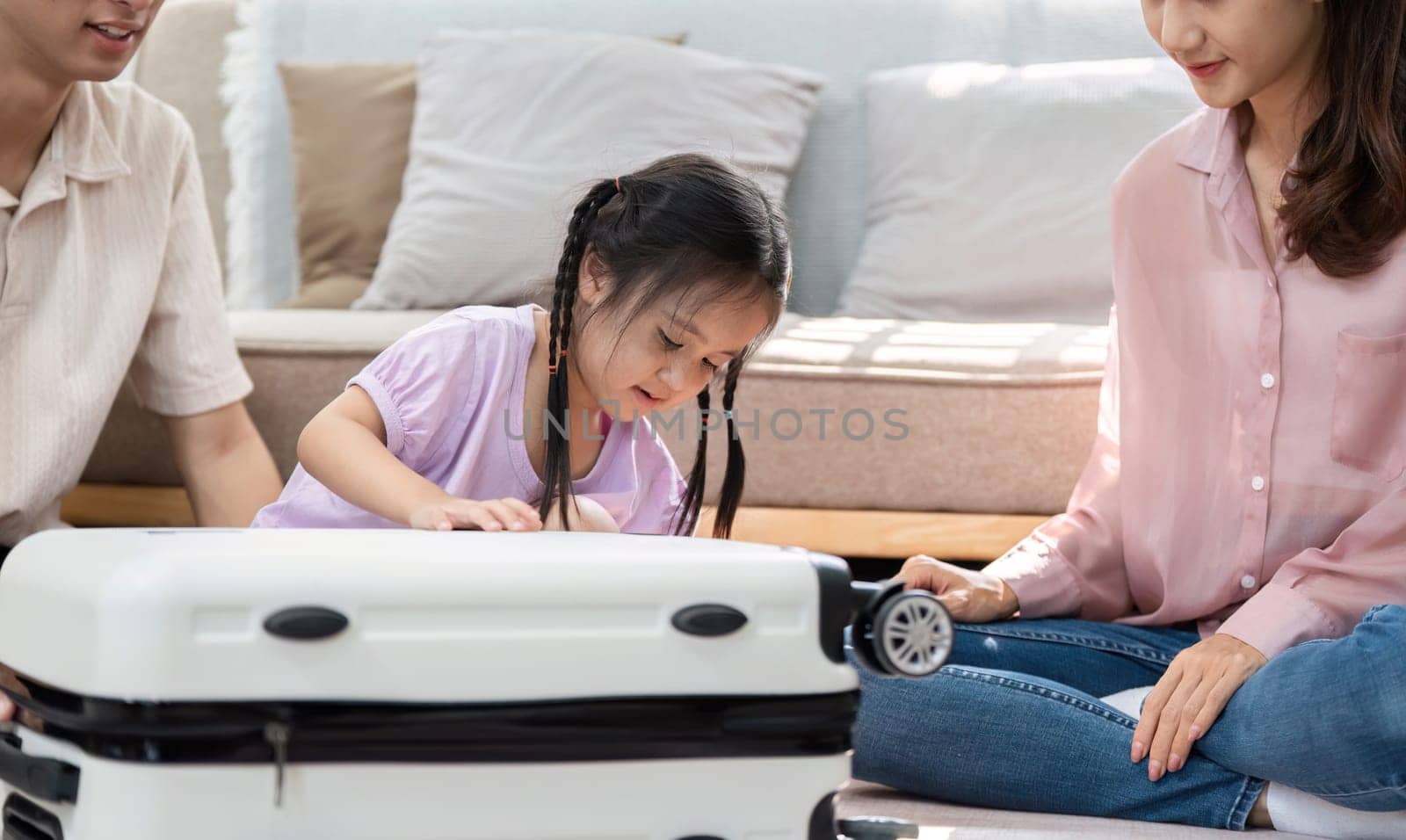 A family gathers at home to prepare for an upcoming trip, with a little girl excitedly inspecting a suitcase, reflecting moments of connection and adventure.