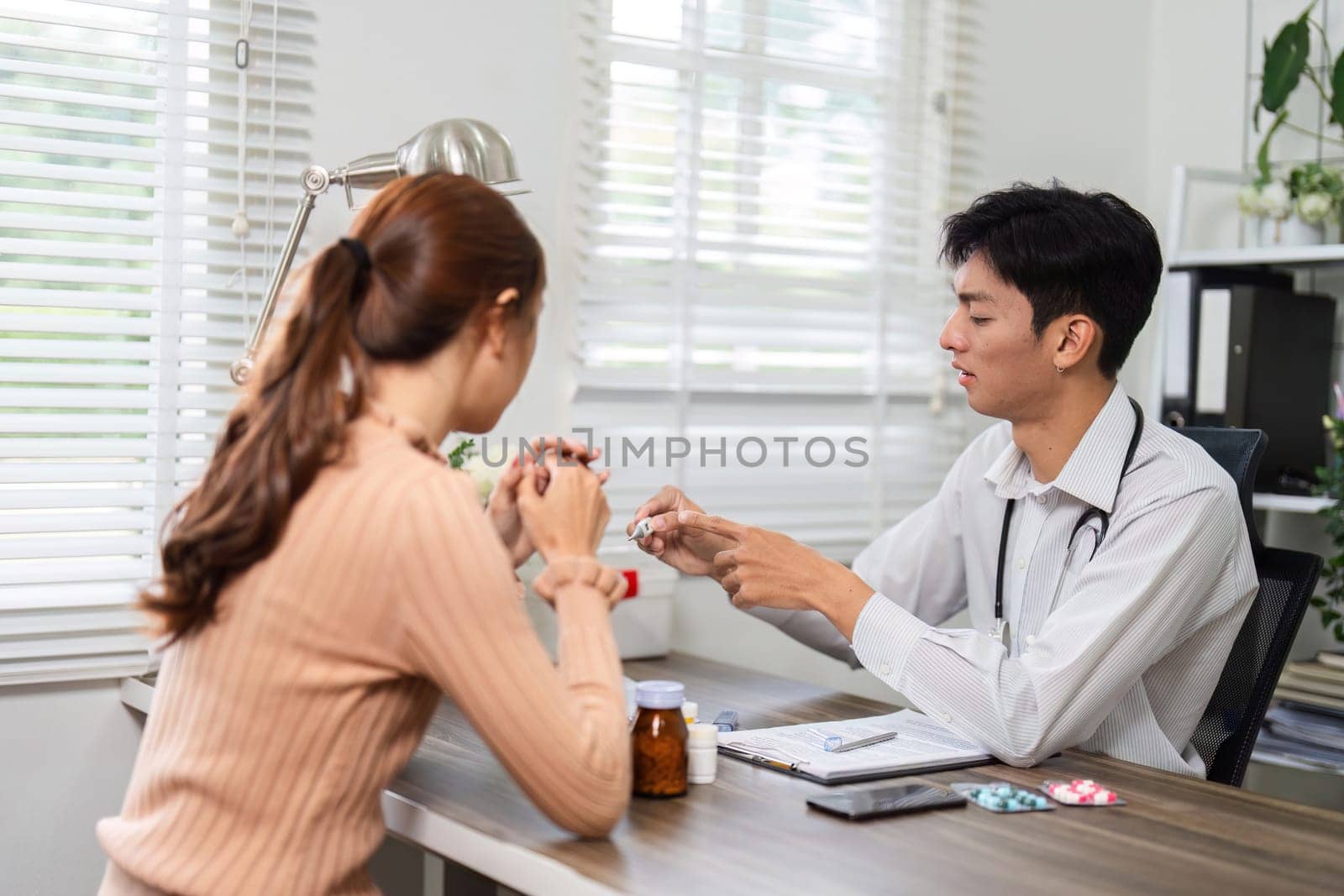 A healthcare professional attentively discusses medication options with a woman during a private consultation, ensuring her understanding and comfort.