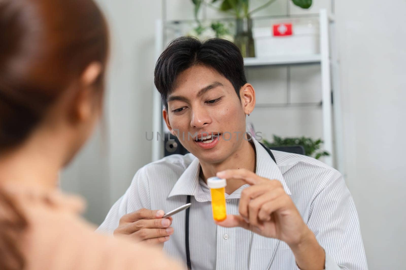 A doctor explains treatment options using a prescription bottle during an informative patient consultation.