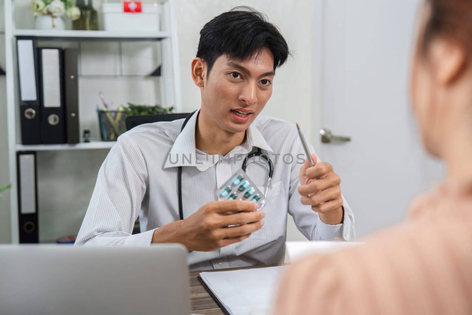 The healthcare provider explains medication details using a pill pack, ensuring the patient understands their treatment.
