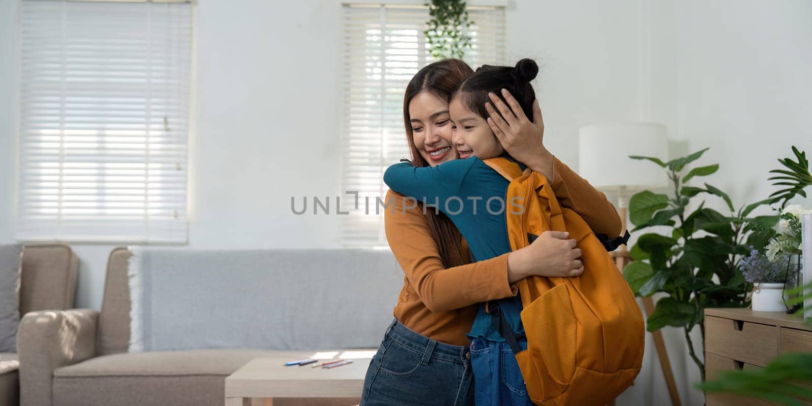 A touching hug between a woman and a girl signifies the love and support shared as they prepare for the new school year, enhancing family bonds.