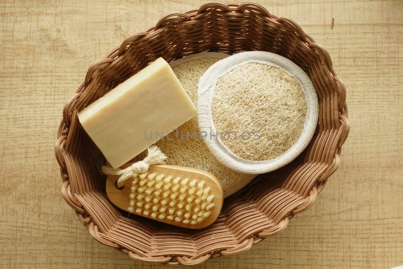 A basket filled with loofah, soap, and a scrubbing brush for bathing.