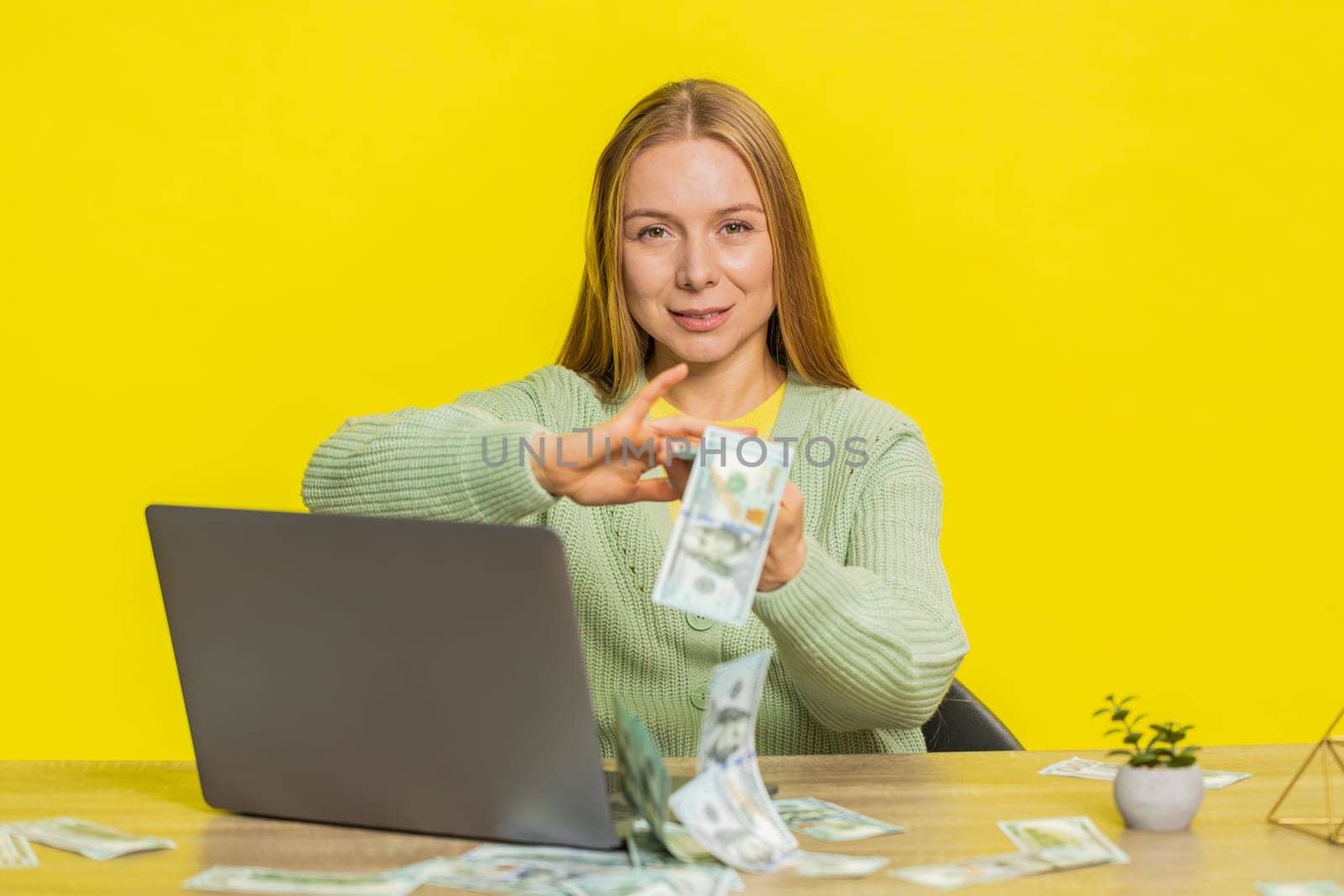 Caucasian rich woman wasting throwing sharing money dollar cash around more tips big profit winning lottery casino jackpot, successful shopping payment purchase cashback. Girl on yellow background.