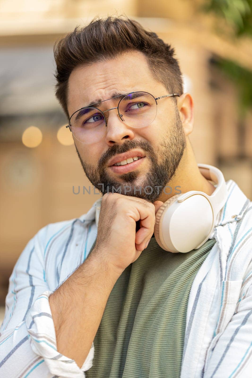Sad unhappy young man tourist thinks over life concerns, suffers from unfair situation. Problem, feeling bad annoyed, burnout grief. Frustrated depressed lonely adult guy standing on city street.