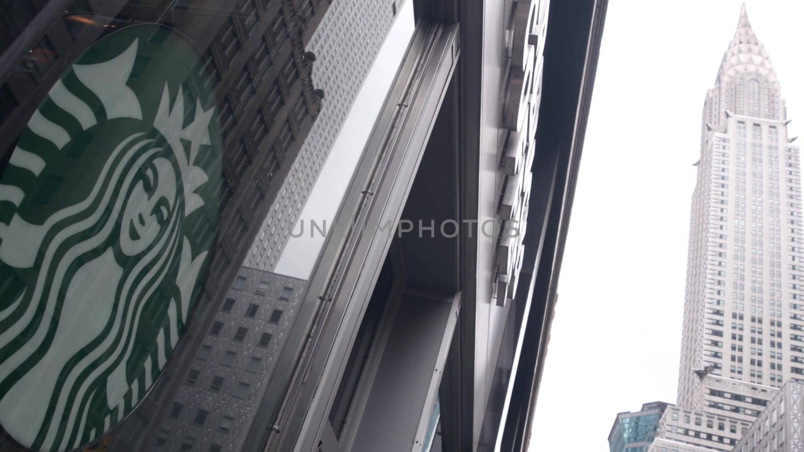 New York City, United States - 29 Aug 2023: Manhattan Midtown street, Lexington Lex avenue. Urban architecture in USA. Starbucks coffee logo, Chrysler building. High-rise skyscraper tower. NYC symbol.