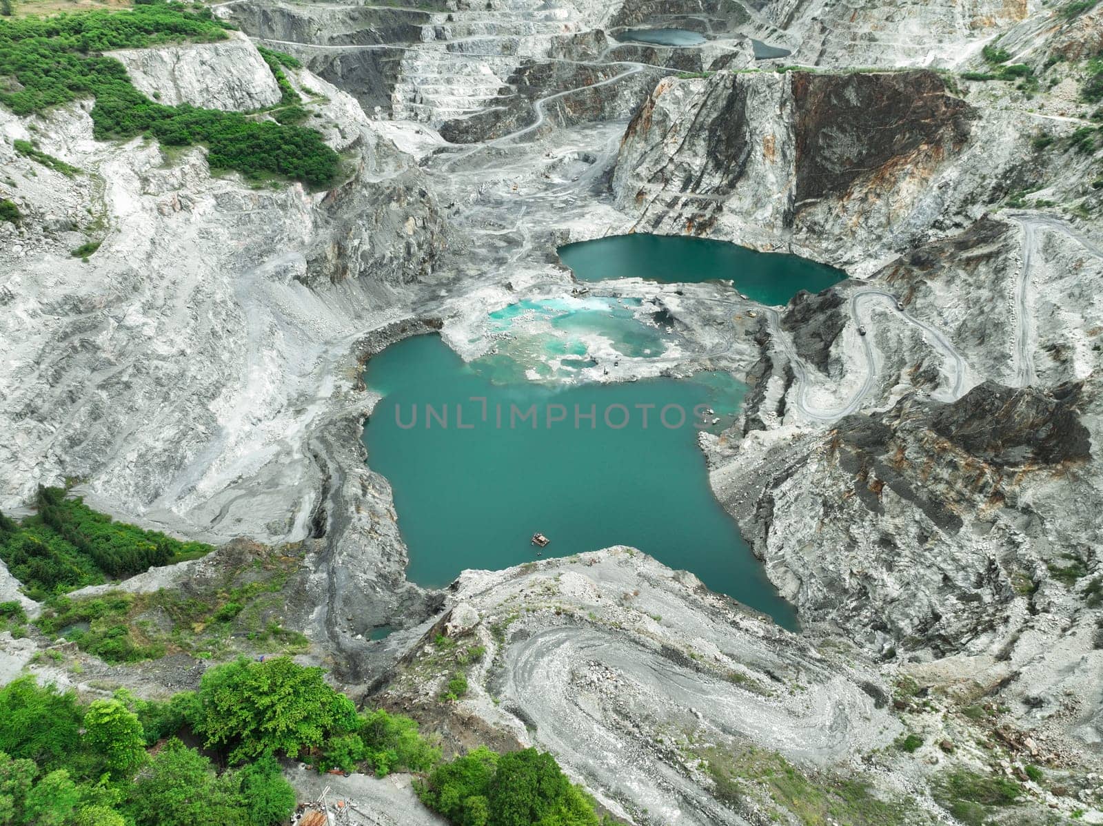 Open pit mine industry. Limestone quarry with backhoe and truck in operation. Heavy machinery in mining industry and construction material supply. Landscape of resource extraction in a industrial site