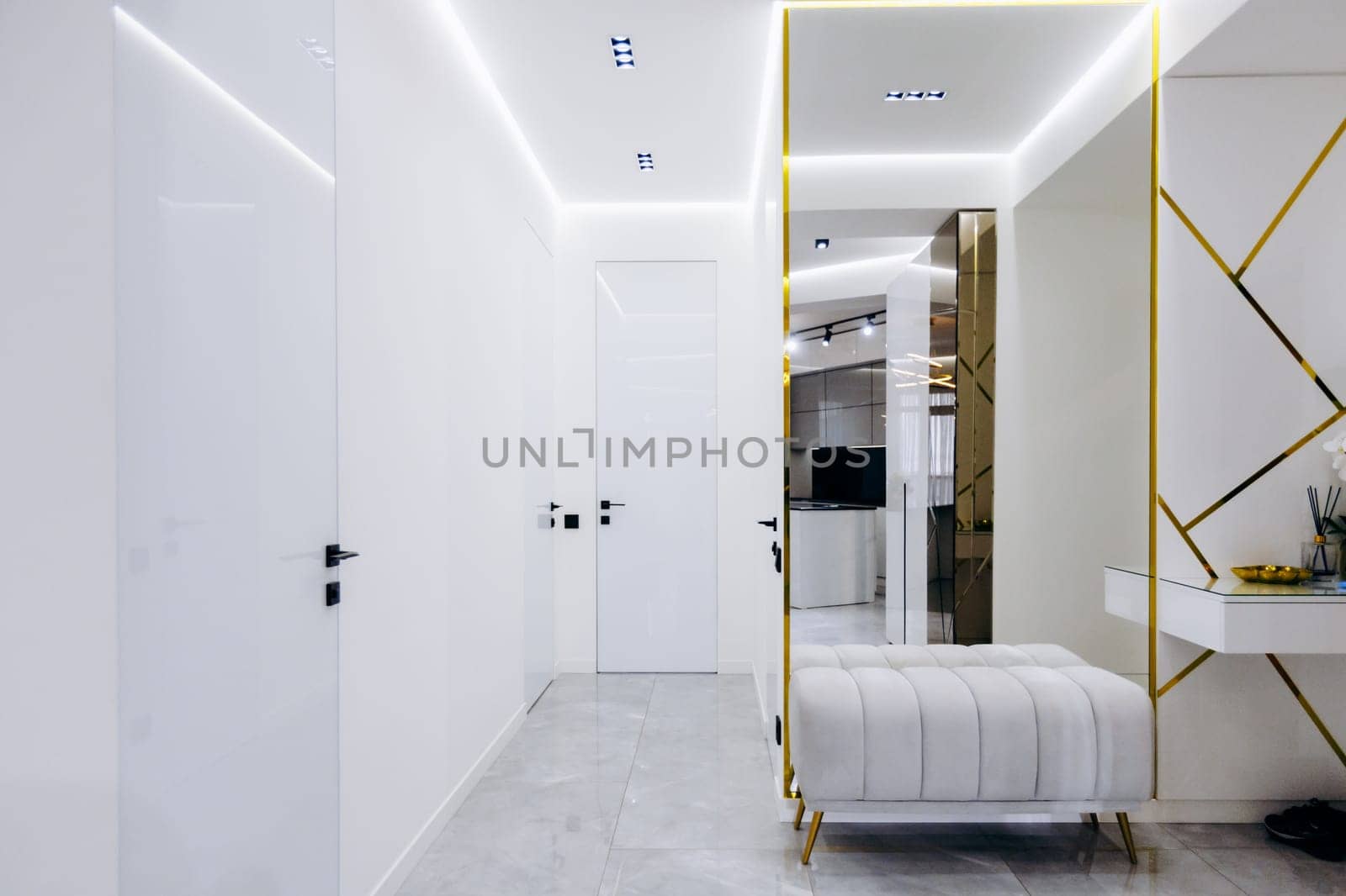 A long hallway featuring a wooden bench elegantly placed against the wall, adorned with a stylish mirror hung on the wall surface