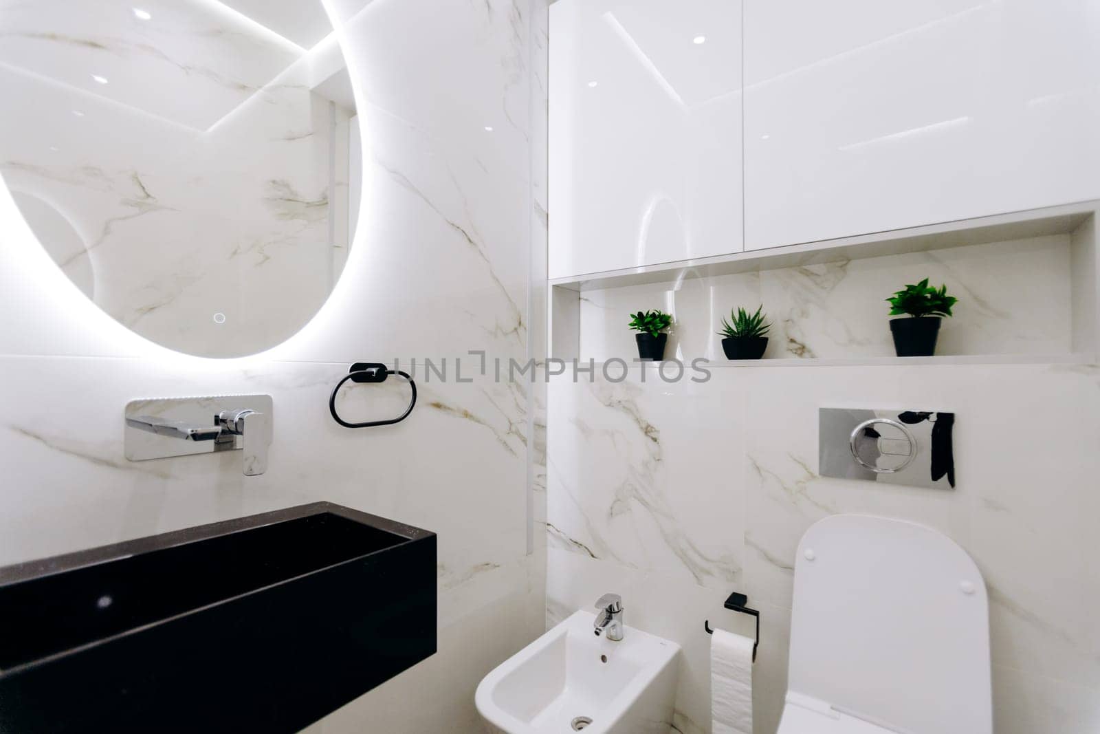 This is a typical bathroom that includes essential fixtures such as a toilet, a sink, and a mirror for personal grooming and hygiene