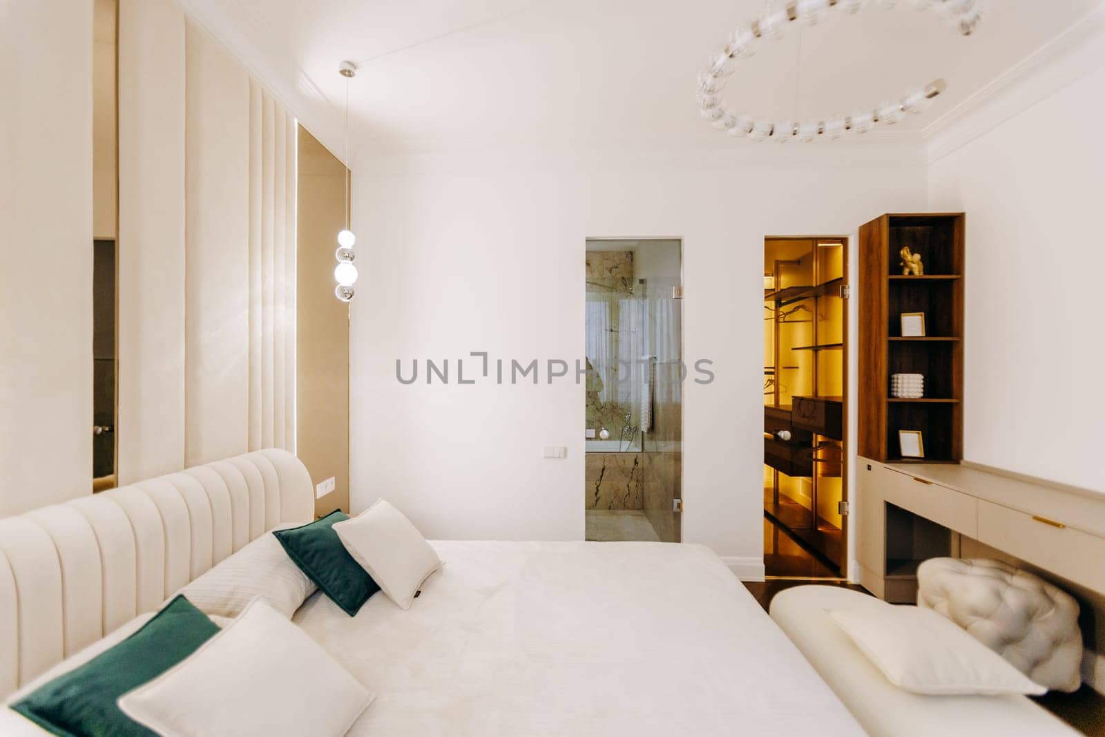 This is a spacious bedroom that features a large bed, complemented by a walkin closet that offers ample storage space for clothing and accessories