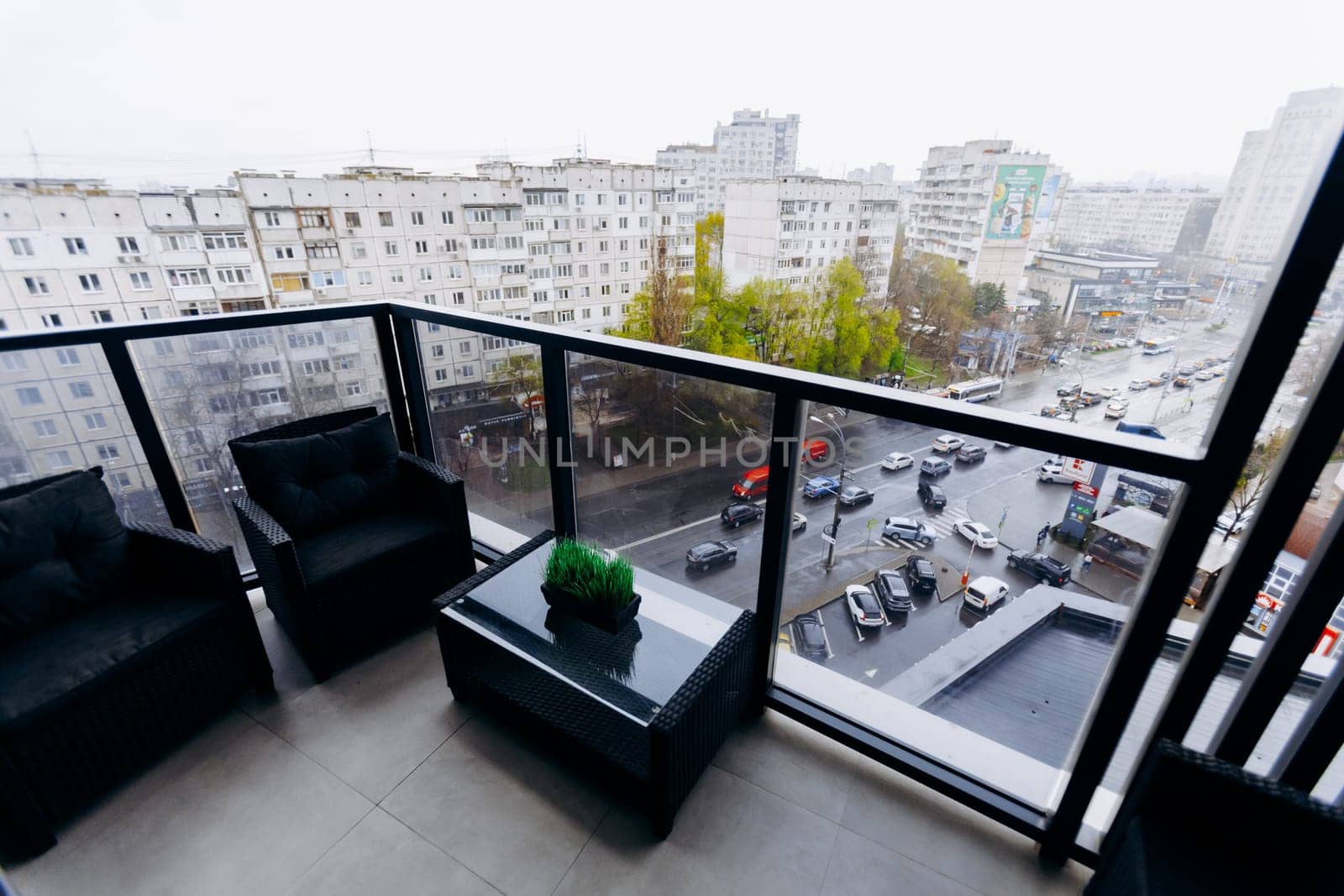 A lovely balcony that features chairs and a small table, offering an impressive view of the bustling city below, perfect for relaxation
