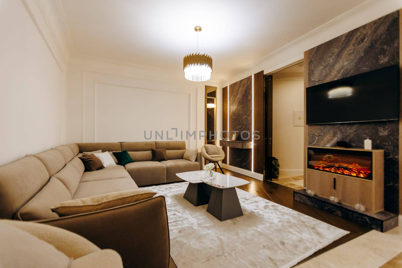 A spacious living room that features a comfortable couch, a stylish coffee table, a warm fireplace, and a modern television for entertainment