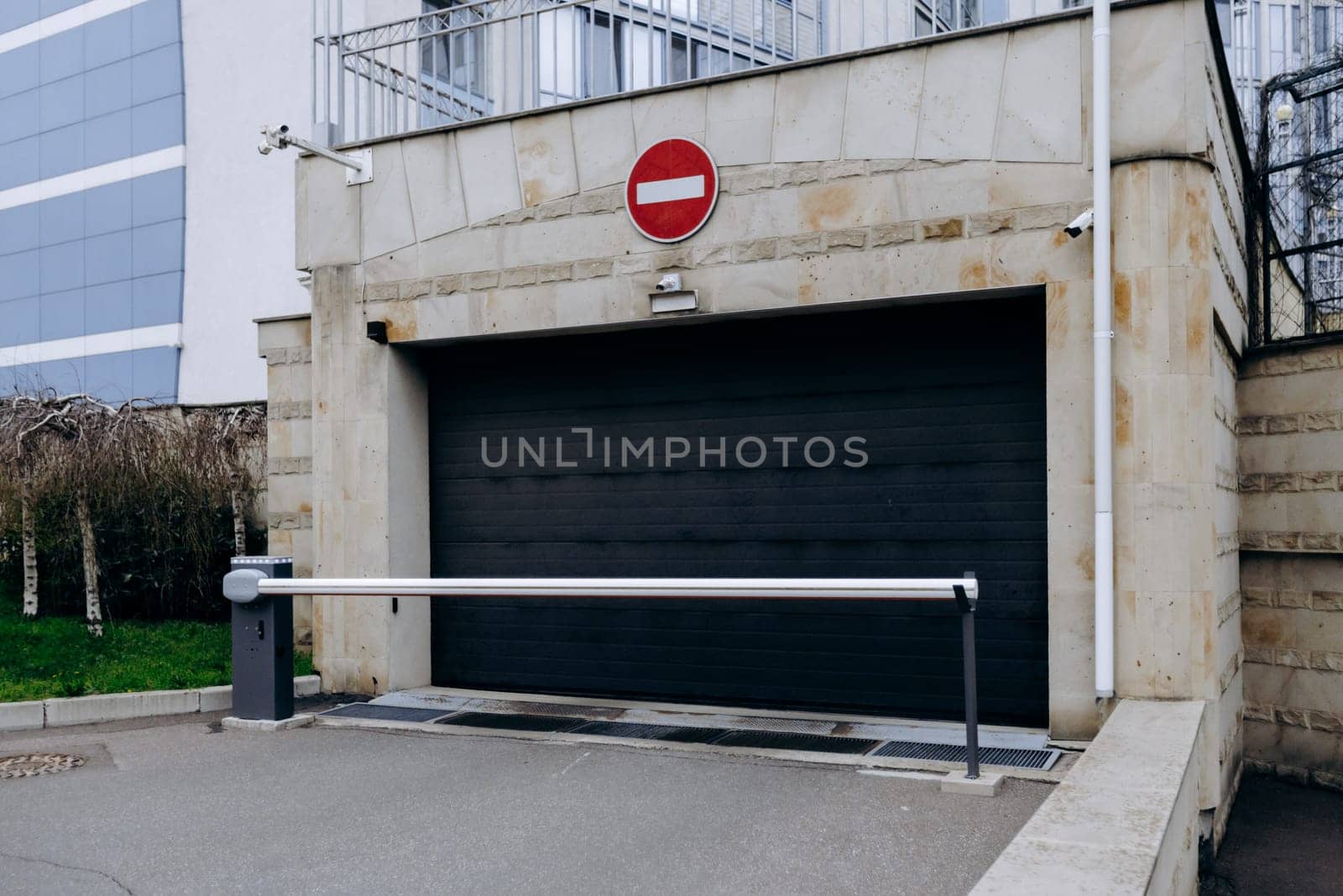 A black garage door that prominently features a no entry sign placed on it, indicating restrictions on access or usage of the area