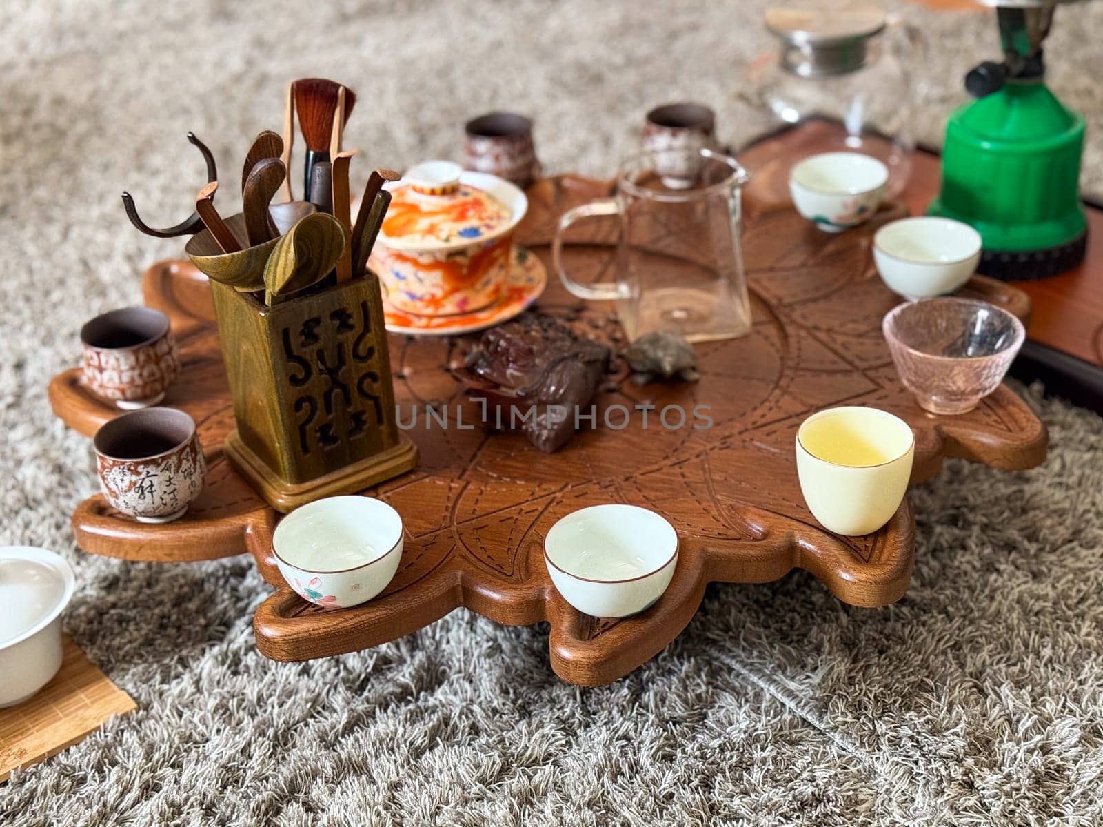 Vintage ceramic teapot and cups on linen with eucalyptus and moonstone jewelry. Tea ceremony and sensory aesthetics.