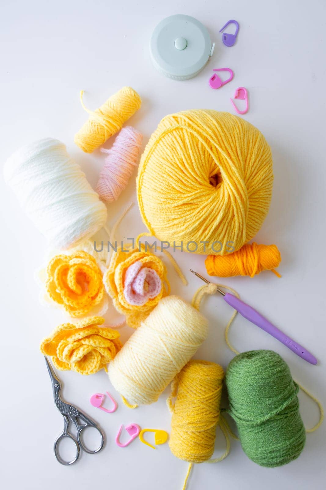 Colorful yarn and crochet tools on a white background.