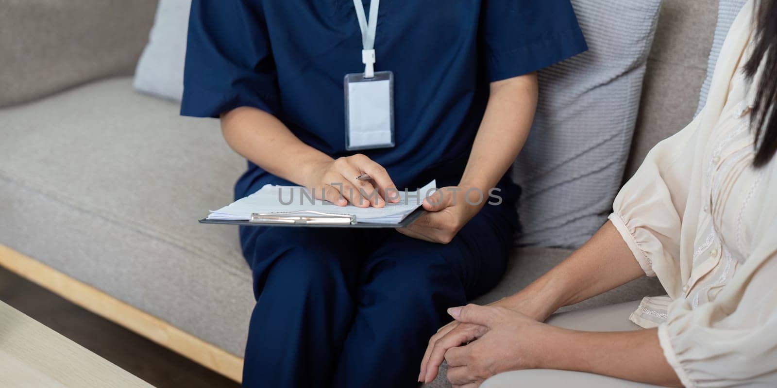 The caregiver engages with the patient, taking notes and ensuring the patient's health needs are understood and addressed.