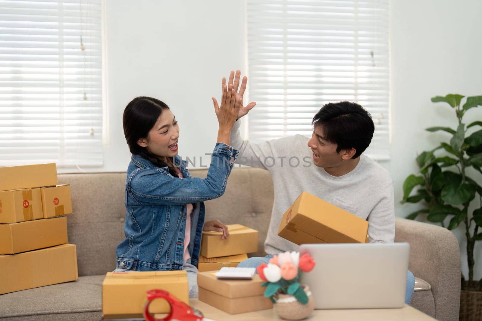 In a lively moment of triumph, this couple celebrates their hard work and collaboration in building their online business, showcasing their dynamic relationship.