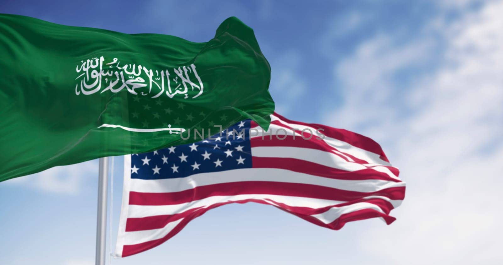 3D render of Saudi Arabia and United States flags waving side by side. Symbol of international identity, patriotism, and cultural unity between East and West