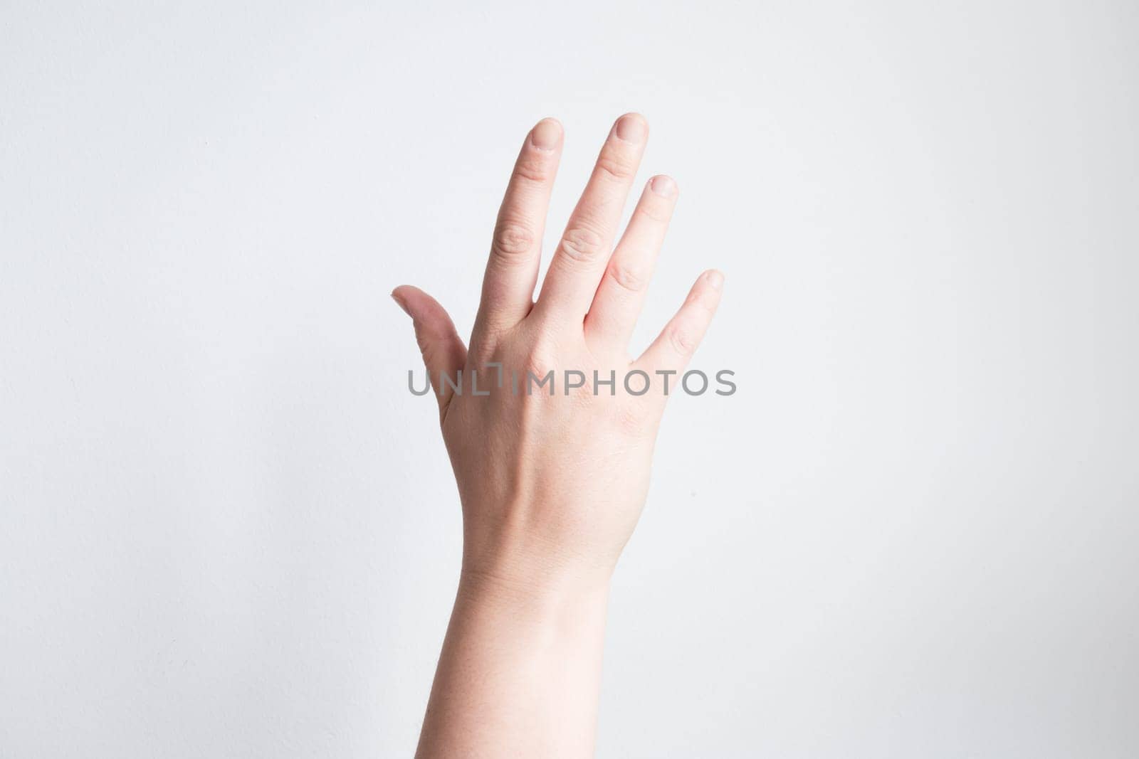 Caucasian adult female hand raised against white background.