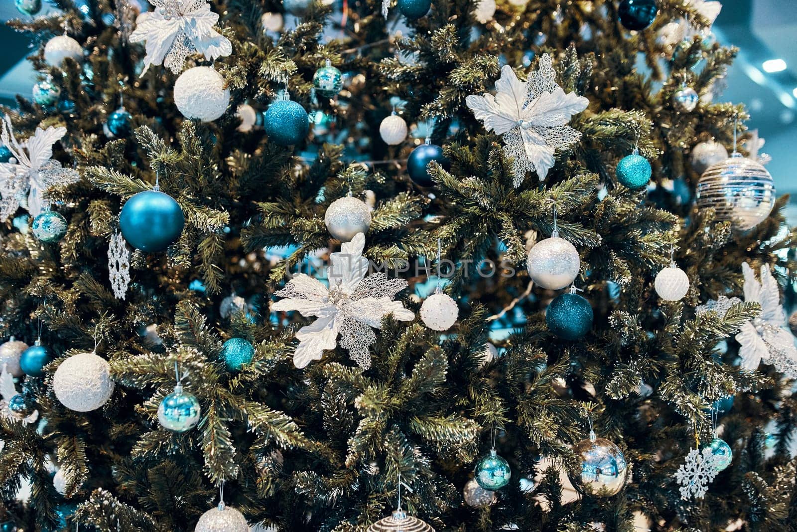 Decorated Christmas tree. Decorated Golden Christmas tree with patchwork ornament artificial stars, white flowers, for New year.