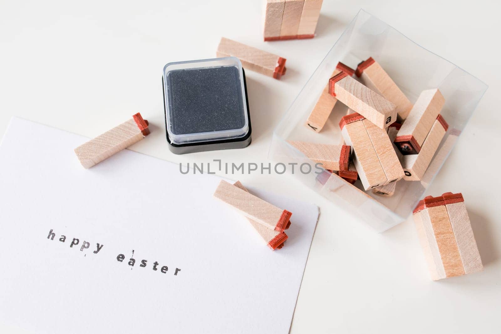 Happy Easter letter stamping with wooden blocks and ink pad.