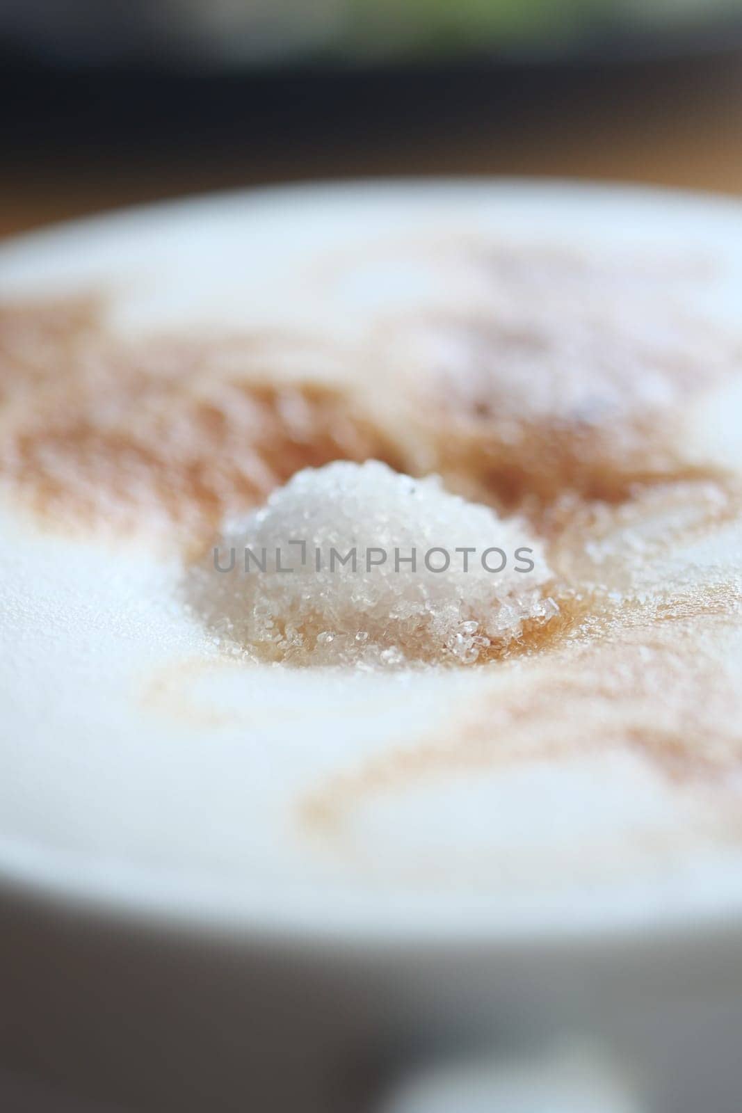 sugar pouring on a coffee .