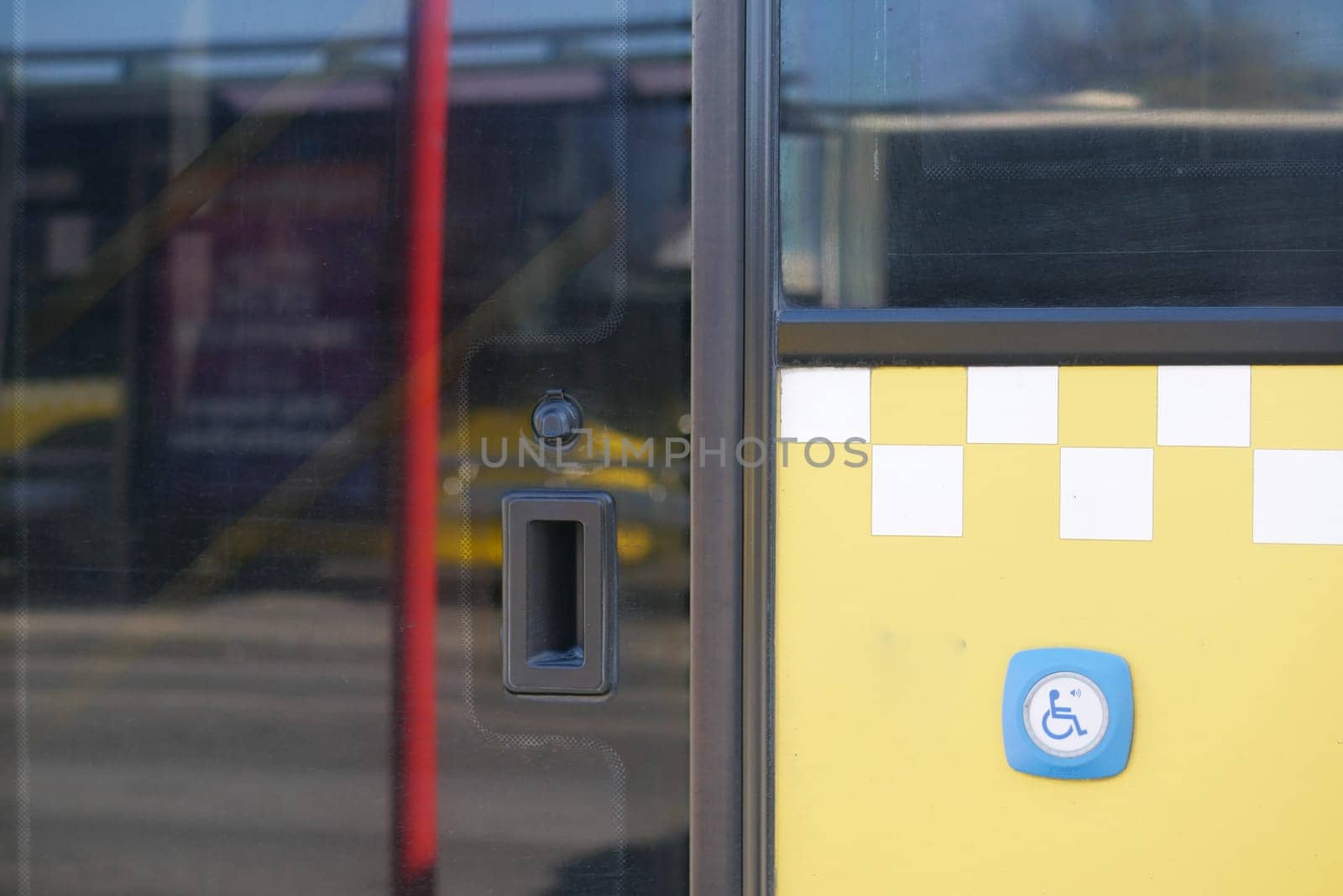 Close view of a city bus entrance showing accessibility details and buttons