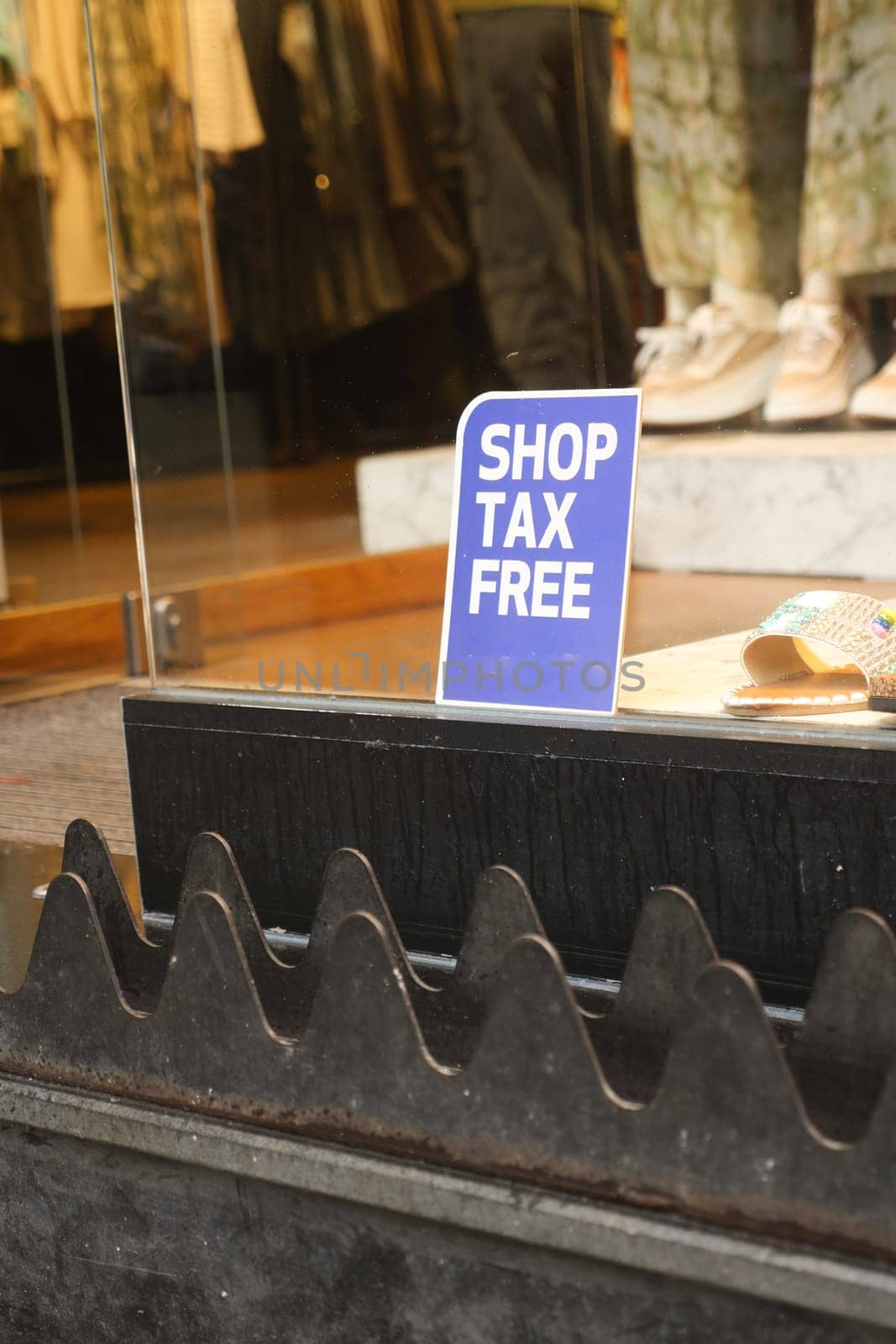 A tax free shopping sign displayed in a store window, inviting customers.
