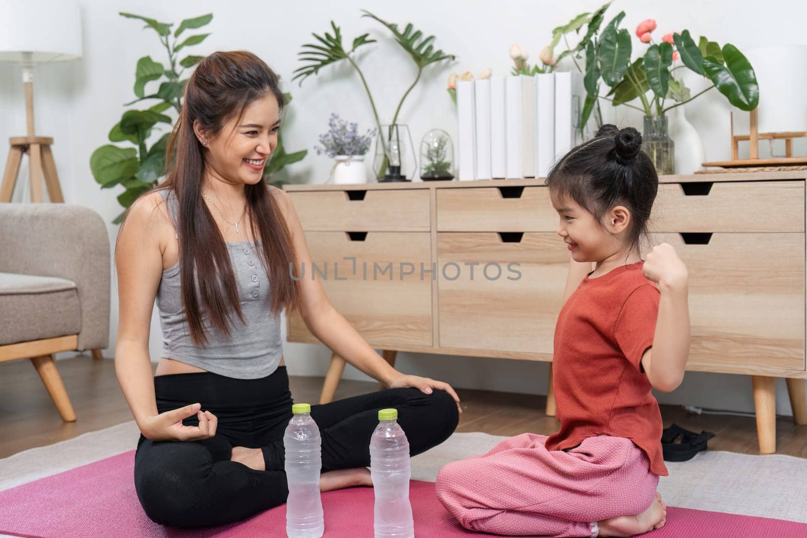 Amidst a workout, a mother engages her daughter in a moment of mindfulness, highlighting both strength and emotional connection.