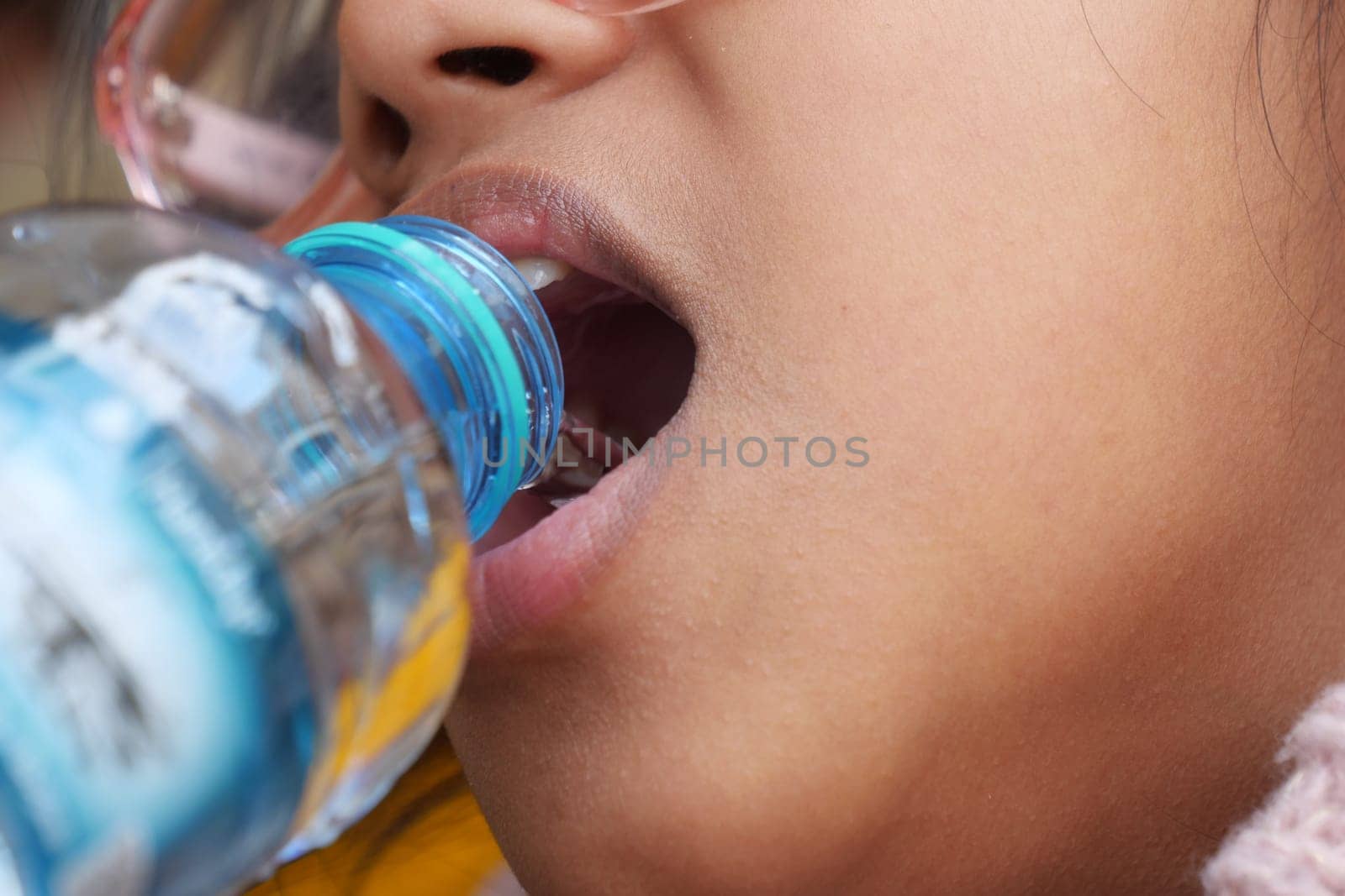 Teenager refreshes with water while enjoying a warm outdoor day.