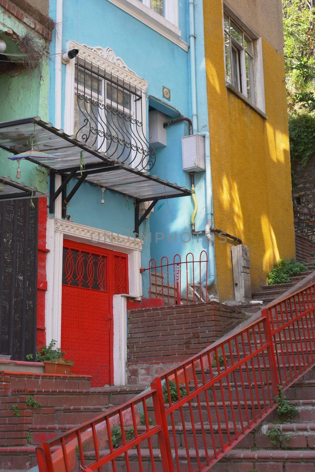 Brightly painted buildings line a stairway with lush greenery peeking through.