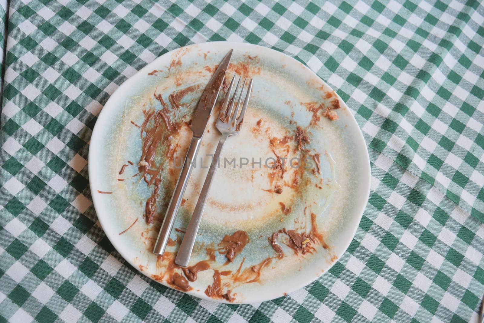 The plate shows remnants of dessert, with utensils resting beside it.