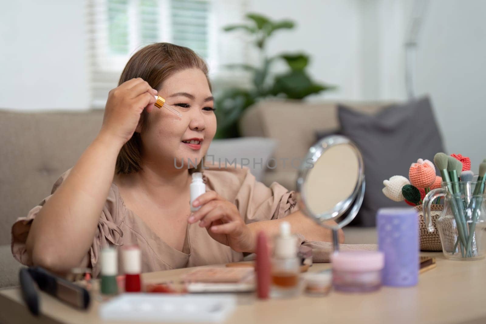 A beauty enthusiast carefully applies serum on her cheeks, embodying self-love and healthy skin practices in a well-organized beauty area.
