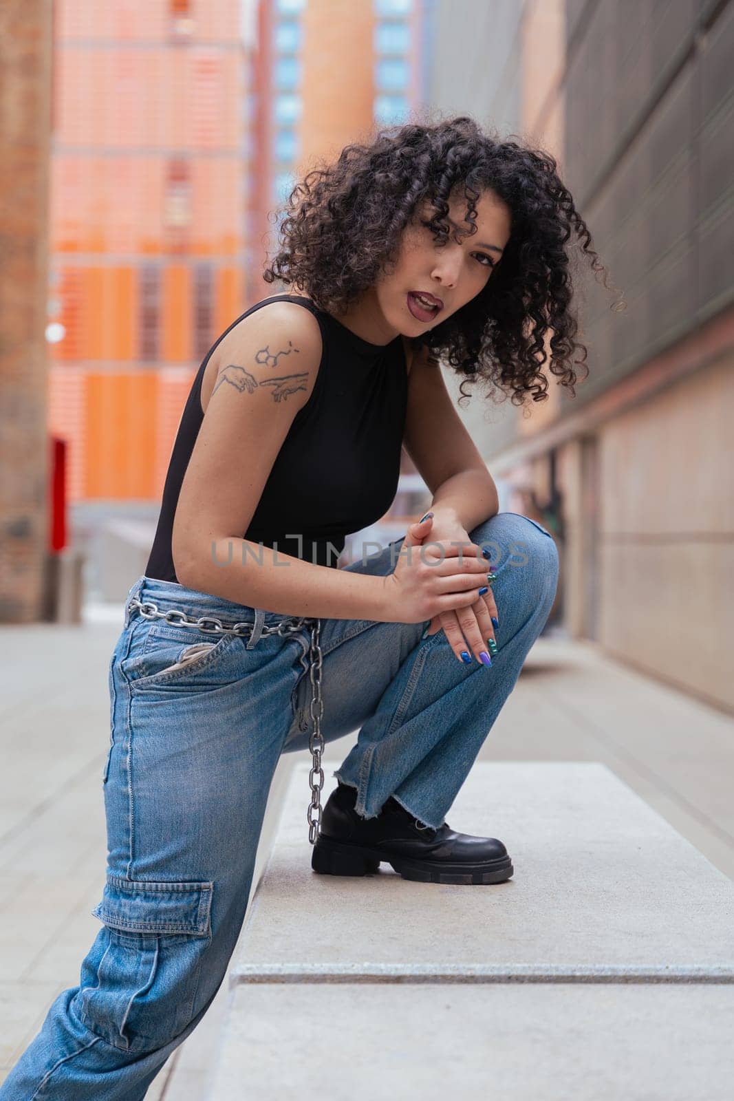 African American woman dancing in a creative pose between benches in an urban setting. he wears casual clothes and shows balance,strength, and expression. Concept of movement, art,and freedom.Vertical