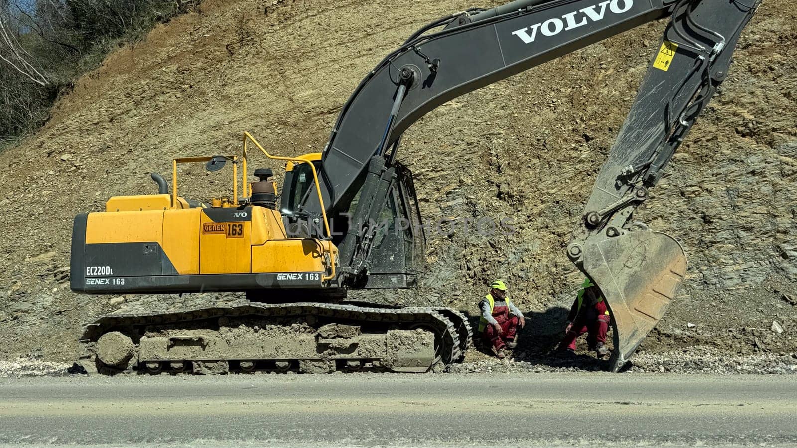 Budva, Montenegro - April 10, 2025: repair of the Budva - Tivat road. Workers rest near the excavator. High quality photos