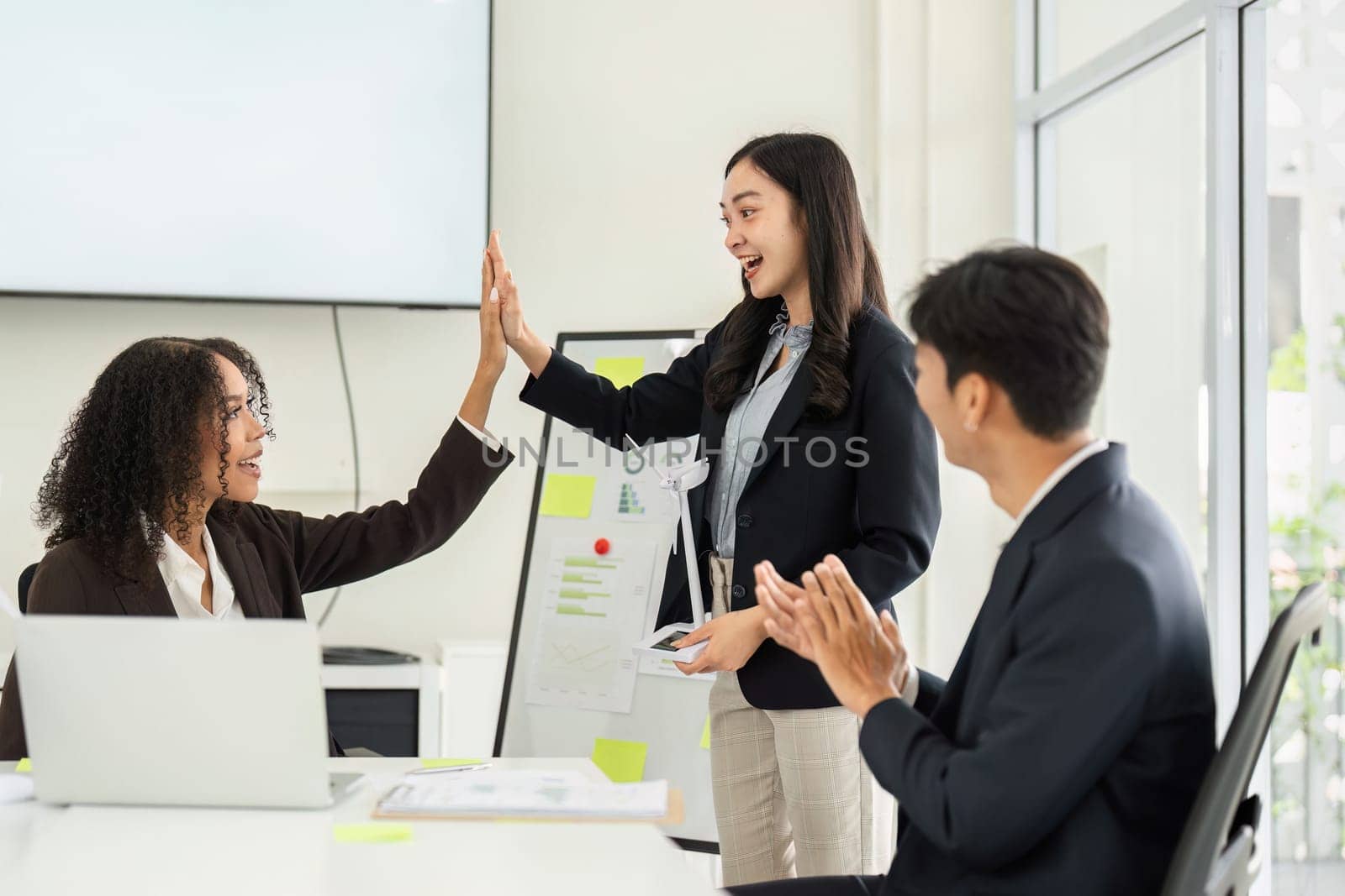In a cheerful setting, colleagues celebrate their successes in ESG initiatives, highlighting teamwork and positive outcomes.