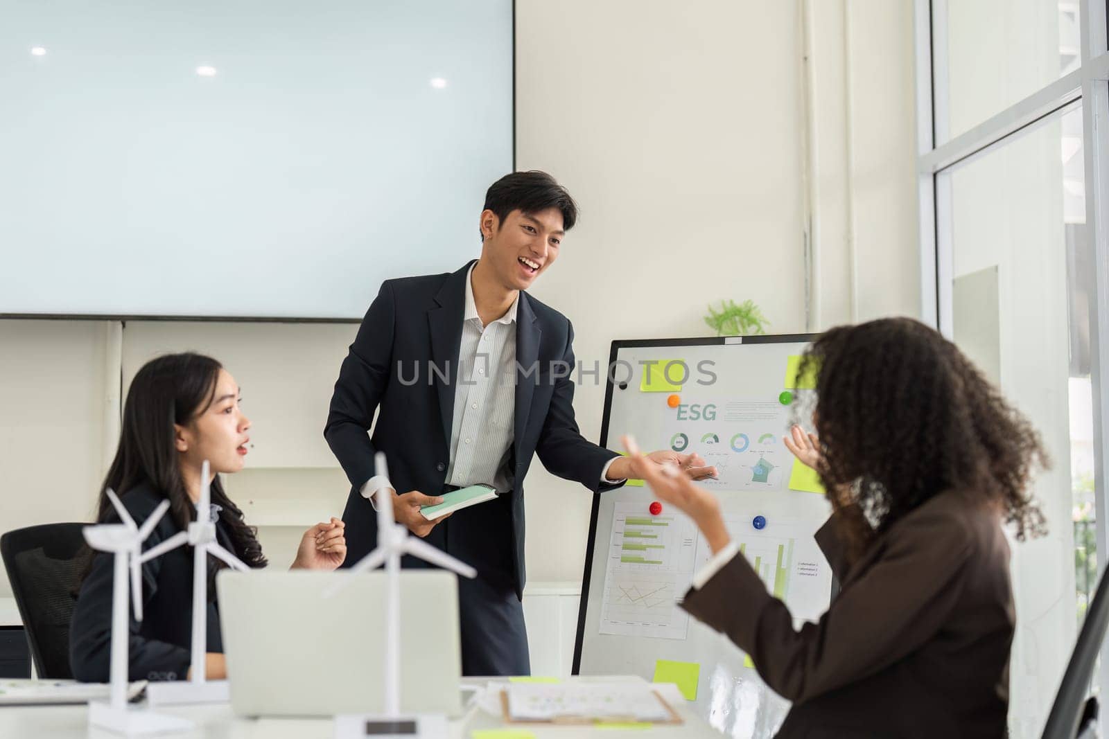 A group of colleagues brainstormes innovative ESG strategies in a modern office setting, emphasizing teamwork and sustainability.