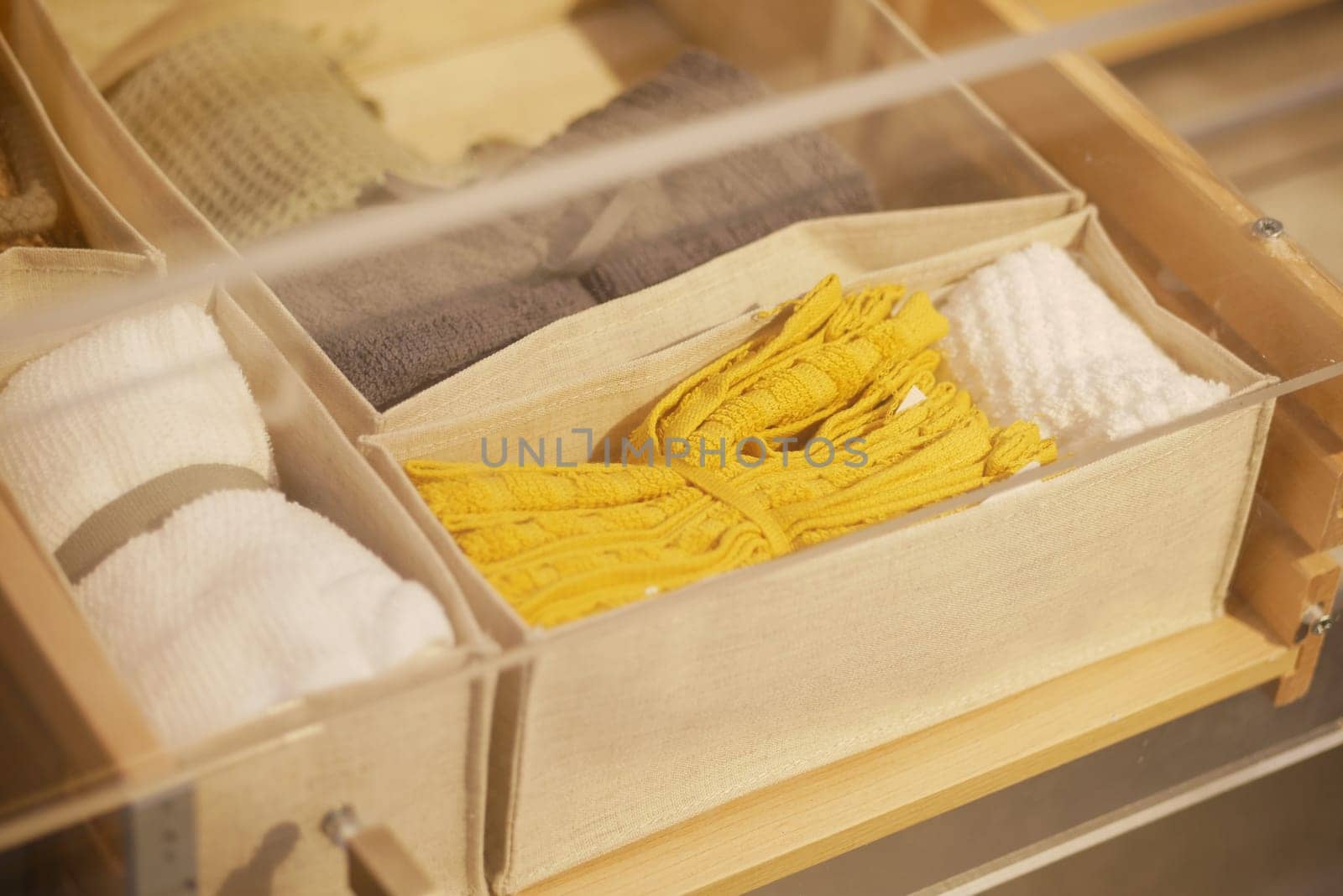 Tidy arrangement of textiles including towels and decorative items in boxes.