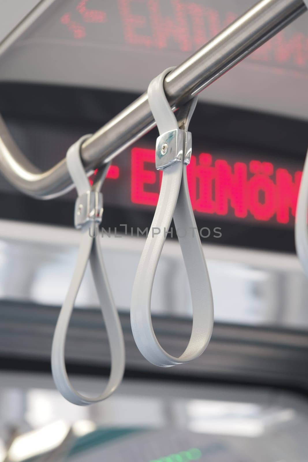 Hand grips hang from the ceiling of a bus, providing support for passengers.