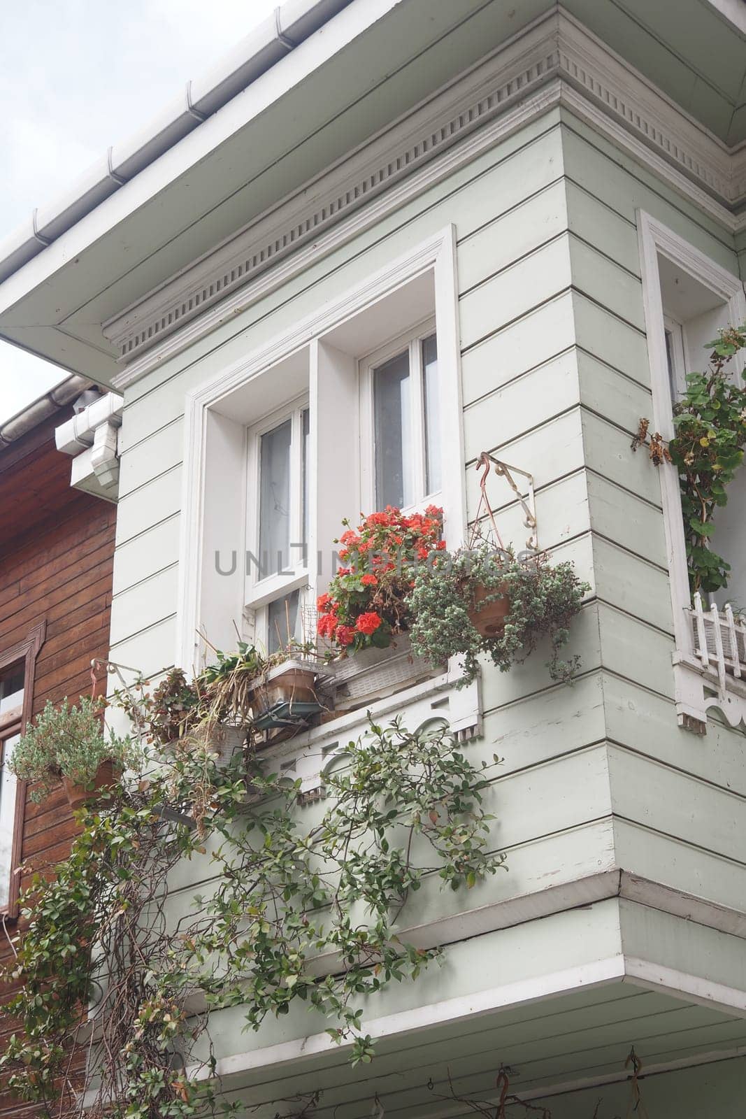 Colorful flowers and greenery adorn a charming balcony of a wooden house.