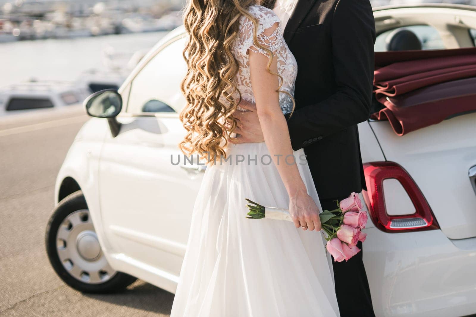 Wedding bouquet of white and pink roses and with newlywed couple.