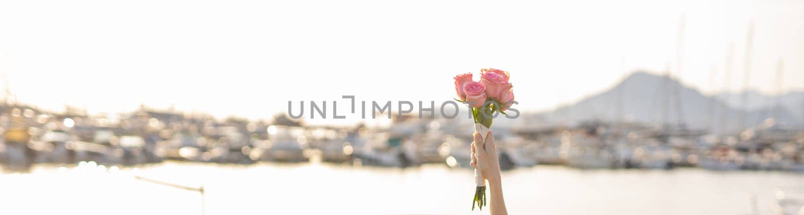 Banner hand holding a beautiful bouquet of roses flowers. Bouquet of flowers for congratulations. Copy space for text. Wedding bouquet.